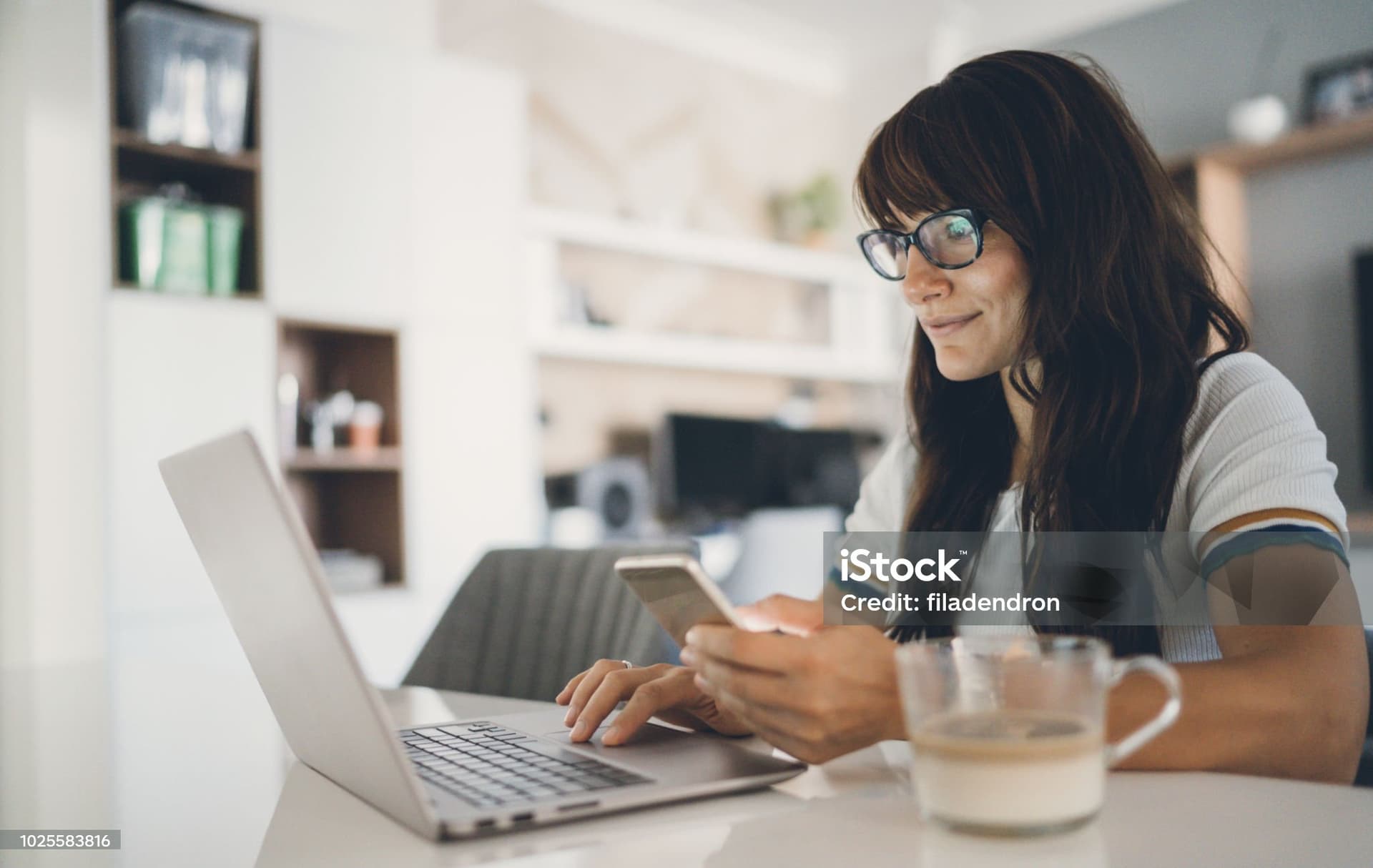 Woman completing online verification on laptop and phone
